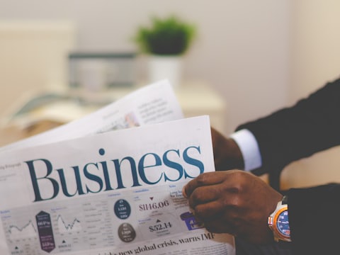 A reader with the business section of a newspaper, illustrating the business brief